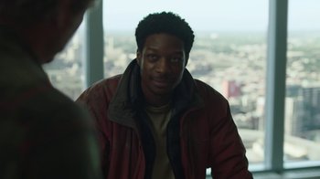 Movie still from “The Last of Us” (2023), created by Neil Druckmann – A man in a red jacket is looking at the camera; Close Up shot, Over the shoulder angle