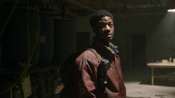 Movie still from “The Last of Us” (2023), created by Neil Druckmann – A man with a backpack standing in an abandoned building; Close Up shot, Low angle