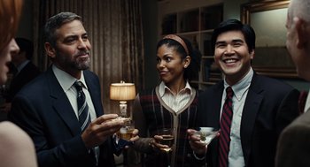 Movie still from “Burn After Reading” (2008), directed by Joel Coen – A group of people standing next to each other holding drinks; Medium shot, Over the shoulder angle