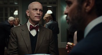 Movie still from “Burn After Reading” (2008), directed by Joel Coen – A man in a suit and a bow tie is talking to another man in a suit; Close Up shot, Over the shoulder angle