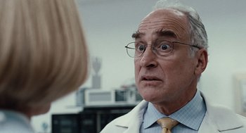 Movie still from “Burn After Reading” (2008), directed by Joel Coen – An older man wearing a white lab coat; Close Up shot, Over the shoulder angle