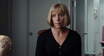 Movie still from “Burn After Reading” (2008), directed by Joel Coen – A woman sitting in a chair looking at the camera; Close Up shot, Over the shoulder angle