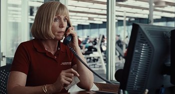 Movie still from “Burn After Reading” (2008), directed by Joel Coen – A woman talking on a phone while sitting in front of a computer; Close Up shot, Over the shoulder angle