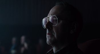 Movie still from “Burn After Reading” (2008), directed by Joel Coen – A person wearing glasses; Close Up shot, Low angle