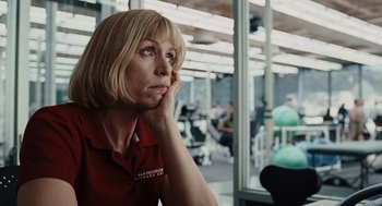 Movie still from “Burn After Reading” (2008), directed by Joel Coen – A woman in a red shirt is sitting in front of a window; Close Up shot, Low angle