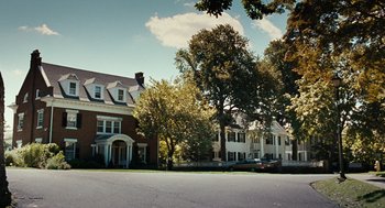 Movie still from “Burn After Reading” (2008), directed by Joel Coen – A view of a street with a house in the background; Extreme Wide shot, Low angle