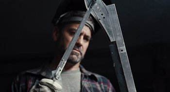 Movie still from “Burn After Reading” (2008), directed by Joel Coen – A man wearing a hard hat and holding a pair of scissors; Close Up shot, Low angle