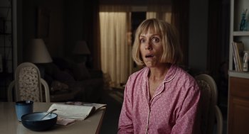 Movie still from “Burn After Reading” (2008), directed by Joel Coen – A woman in a pink shirt is sitting at a table; Close Up shot, Low angle