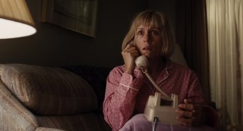 Movie still from “Burn After Reading” (2008), directed by Joel Coen – A woman sitting on a couch talking on a phone; Medium shot, Low angle