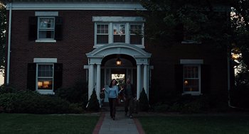 Movie still from “Burn After Reading” (2008), directed by Joel Coen – Two people walking down a sidewalk in front of a building; Wide shot, Low angle