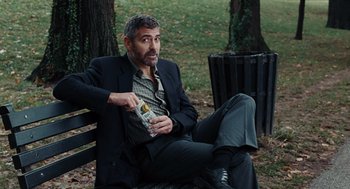 Movie still from “Burn After Reading” (2008), directed by Joel Coen – A man sitting on top of a wooden park bench; Medium shot, Over the shoulder angle