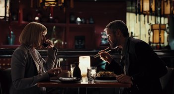 Movie still from “Burn After Reading” (2008), directed by Joel Coen – A man and a woman sitting at a dinner table; Medium shot, Over the shoulder angle