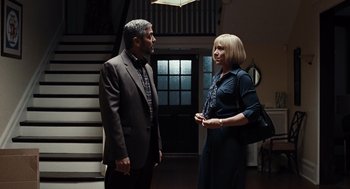 Movie still from “Burn After Reading” (2008), directed by Joel Coen – A man and a woman standing next to each other in front of a staircase; Medium shot, Low angle