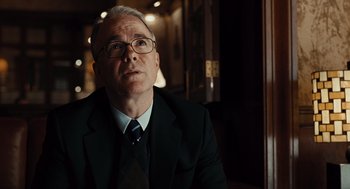 Movie still from “Burn After Reading” (2008), directed by Joel Coen – An older man in a suit and tie; Close Up shot, Over the shoulder angle