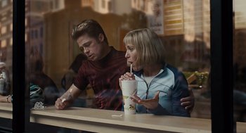 Movie still from “Burn After Reading” (2008), directed by Joel Coen – Two people sitting at a table in front of a drink; Medium shot, Over the shoulder angle