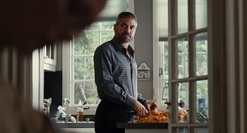 Movie still from “Burn After Reading” (2008), directed by Joel Coen – A man standing in front of a table with food; Medium shot, Over the shoulder angle
