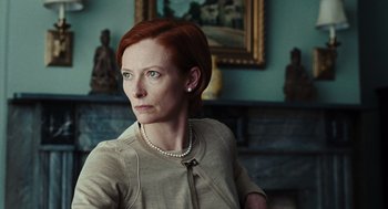 Movie still from “Burn After Reading” (2008), directed by Joel Coen – A woman with red hair wearing a beige jacket; Close Up shot, Low angle