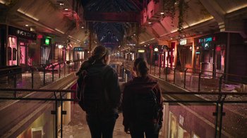 Movie still from “The Last of Us” (2023), created by Neil Druckmann – Two women are walking down a train platform; Wide shot, High angle