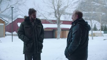 Movie still from “The Last of Us” (2023), created by Neil Druckmann – Two men are standing outside talking to each other; Medium shot, Over the shoulder angle