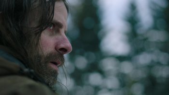 Movie still from “The Last of Us” (2023), created by Neil Druckmann – A person with long hair and a beard; Close Up shot, Low angle