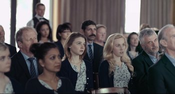 Movie still from “The Lobster” (2015), directed by Yorgos Lanthimos – A group of people sitting in a room; Medium shot, Over the shoulder angle