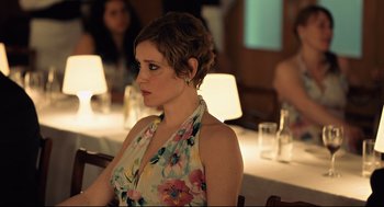 Movie still from “The Lobster” (2015), directed by Yorgos Lanthimos – A woman sitting at a table in front of a group of people; Close Up shot, Over the shoulder angle