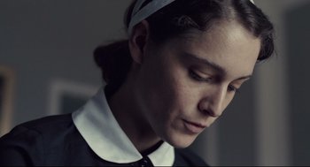 Movie still from “The Lobster” (2015), directed by Yorgos Lanthimos – A woman with a headband is looking down at her face; Close Up shot, Low angle