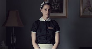 Movie still from “The Lobster” (2015), directed by Yorgos Lanthimos – A woman in a black shirt and a white apron; Medium shot, Low angle