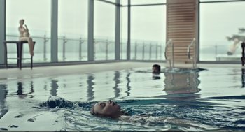 Movie still from “The Lobster” (2015), directed by Yorgos Lanthimos – A man is swimming in a swimming pool; Wide shot, Over the shoulder angle