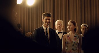 Movie still from “The Lobster” (2015), directed by Yorgos Lanthimos – A man and a woman standing next to an older man; Medium shot, Over the shoulder angle