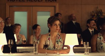 Movie still from “The Lobster” (2015), directed by Yorgos Lanthimos – A woman sitting at a table with a glass of red wine; Medium shot, Over the shoulder angle