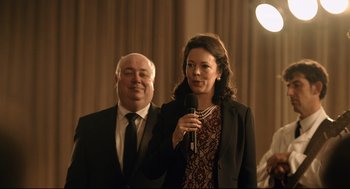 Movie still from “The Lobster” (2015), directed by Yorgos Lanthimos – A man and a woman standing next to each other holding microphones; Medium shot, Over the shoulder angle