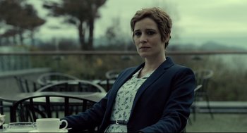 Movie still from “The Lobster” (2015), directed by Yorgos Lanthimos – A woman with short red hair sitting on a bench; Medium shot, Over the shoulder angle