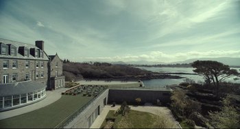 Movie still from “The Lobster” (2015), directed by Yorgos Lanthimos – An aerial view of a building with a lake in the background; Extreme Wide shot, High angle