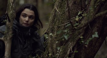 Movie still from “The Lobster” (2015), directed by Yorgos Lanthimos – A woman standing next to a tree in the woods; Close Up shot, Low angle