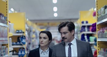 Movie still from “The Lobster” (2015), directed by Yorgos Lanthimos – A man and a woman standing next to each other in a store; Close Up shot, Over the shoulder angle