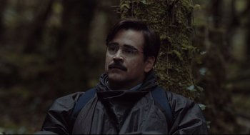 Movie still from “The Lobster” (2015), directed by Yorgos Lanthimos – A man with a beard and mustache wearing a black jacket; Close Up shot, Over the shoulder angle