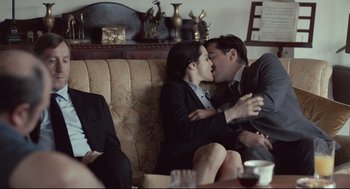 Movie still from “The Lobster” (2015), directed by Yorgos Lanthimos – A man and a woman sitting on a couch kissing; Medium shot, Over the shoulder angle