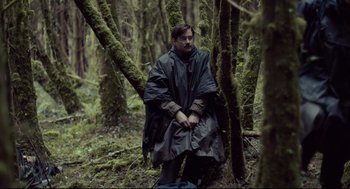 Movie still from “The Lobster” (2015), directed by Yorgos Lanthimos – A man standing in the middle of a forest; Medium shot, Over the shoulder angle
