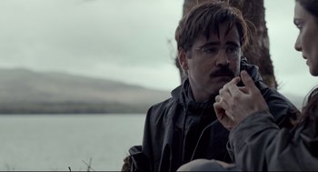 Movie still from “The Lobster” (2015), directed by Yorgos Lanthimos – A man in a black jacket is talking on a phone; Close Up shot, Over the shoulder angle