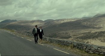 Movie still from “The Lobster” (2015), directed by Yorgos Lanthimos – A man and a woman walking down the side of a road; Wide shot, High angle