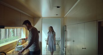 Movie still from “The Lodge” (2019), directed by Severin Fiala – A man and a woman standing in a kitchen; Medium shot, Low angle