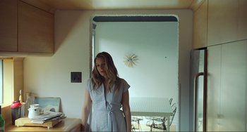 Movie still from “The Lodge” (2019), directed by Severin Fiala – A woman standing in front of an open door; Medium shot, Low angle