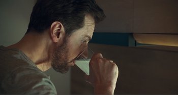 Movie still from “The Lodge” (2019), directed by Severin Fiala – A person drinking a glass of milk; Extreme Close Up shot, Over the shoulder angle