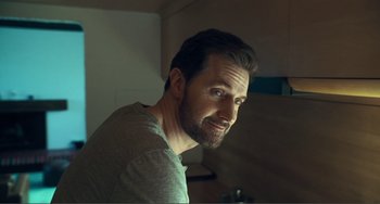 Movie still from “The Lodge” (2019), directed by Severin Fiala – A person smiling for a picture; Close Up shot, Over the shoulder angle