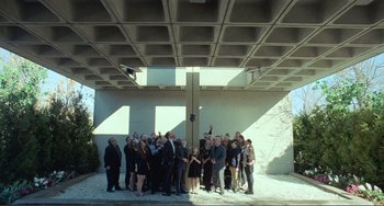 Movie still from “The Lodge” (2019), directed by Severin Fiala – A group of people standing under a building; Extreme Wide shot, Low angle