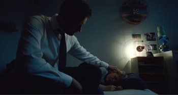 Movie still from “The Lodge” (2019), directed by Severin Fiala – A man and a woman are sitting on a bed; Medium shot, Over the shoulder angle
