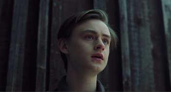 Movie still from “The Lodge” (2019), directed by Severin Fiala – A young man looking up into the air; Close Up shot, Low angle