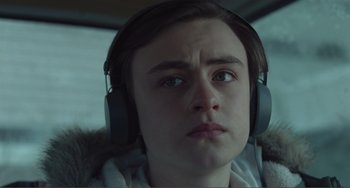 Movie still from “The Lodge” (2019), directed by Severin Fiala – A person with headphones in a vehicle; Close Up shot, Low angle