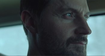 Movie still from “The Lodge” (2019), directed by Severin Fiala – A man with a beard and blue eyes; Close Up shot, Low angle